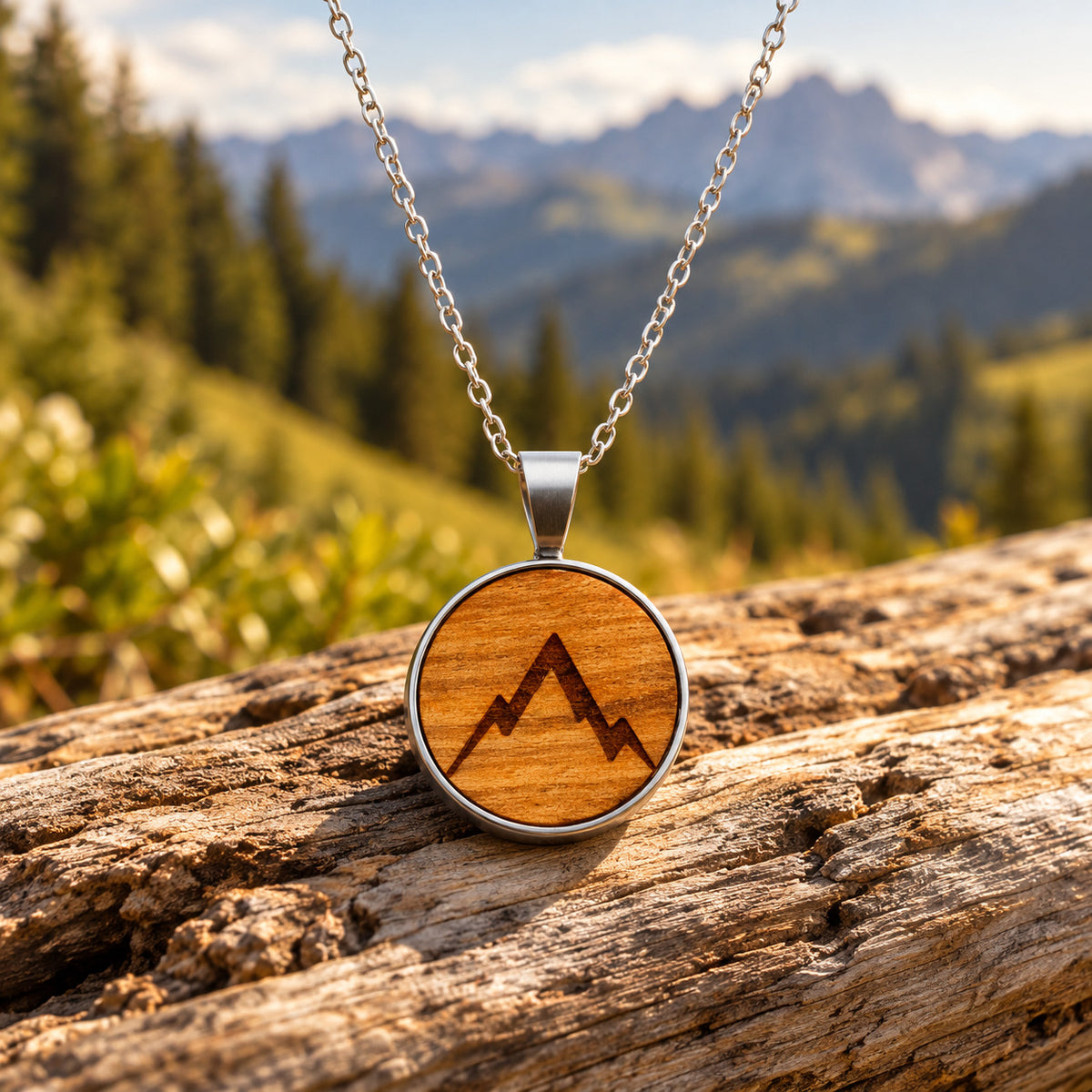 Holz Halskette Gipfelstürmer aus Kirschholz mit Berggravur und Edelstahlkette auf Holz vor alpiner Bergkulisse