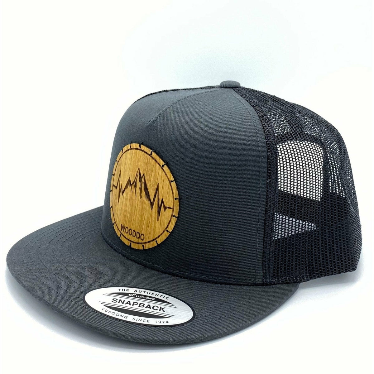 Dunkelgraues Mountainair Mesh Snapback Cap mit Holzemblem Mountainheart, schräg von vorne mit Mesh-Rückseite