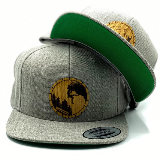 Hellgrau meliertes Natureclassic Snapback Cap mit Holzemblem Wild und Climber, zwei Caps übereinander
