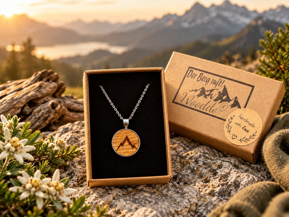 Halskette Gipfelstürmer im geöffneten Schmucketui vor einer Berglandschaft